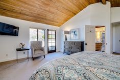 a bedroom with a bed, dresser and television in it