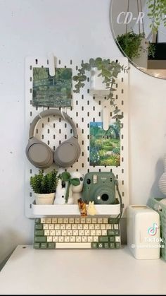 a white desk topped with a computer keyboard and lots of potted plants on top of it