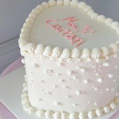 a birthday cake with white frosting and pink decorations