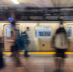 blurry image of people walking in front of a train