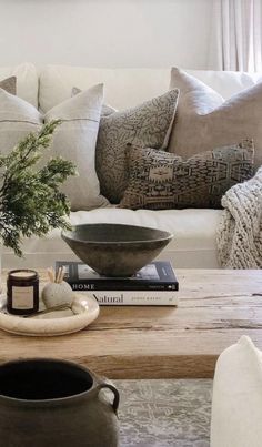 a living room filled with lots of furniture and pillows on top of a wooden table