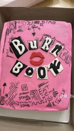 a pink cake with the words burn book written on it in black and white letters