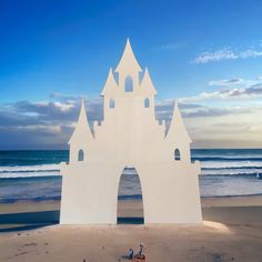 a large sand castle sitting on top of a sandy beach