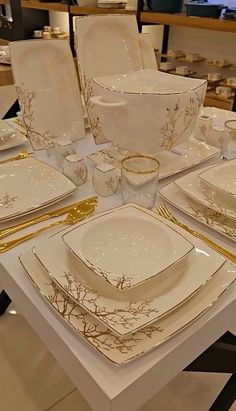 the table is set with white and gold dishes