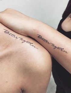 two people with tattoos on their arms and one has the words between them in cursive writing