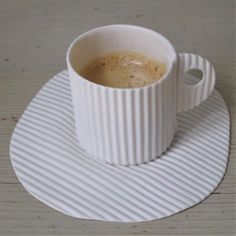 a cup of coffee sitting on top of a white saucer