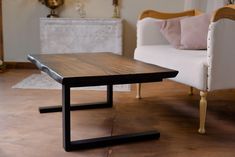 a wooden table sitting on top of a hard wood floor next to a white couch