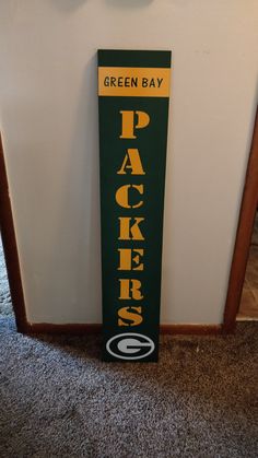 a green bay packers sign hanging on the wall next to a doorway with a clock above it