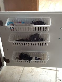 the bottom half of a refrigerator door is filled with plastic bins that hold various items