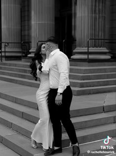 a man and woman are kissing on the steps