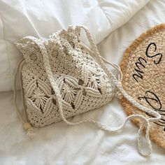 two straw bags sitting on top of a bed