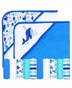 the blue and white baby blanket is next to three rolls of toilet paper