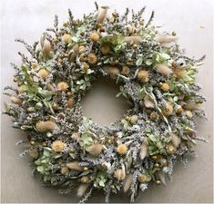 a wreath with dried flowers and leaves on the front of a house or office door