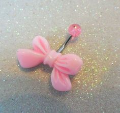 a pink hair pin with a bow on it's end sitting on the ground