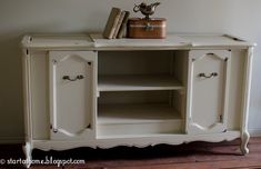 an old white painted cabinet with books on top