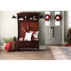 a living room with christmas wreaths on the wall and holiday decorations hanging from the door