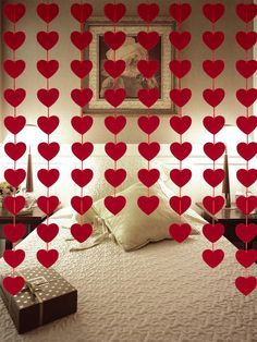 a bed with lots of red hearts hanging from it