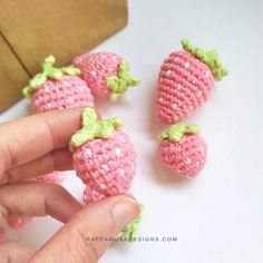 small crocheted strawberries being held by someone's hand