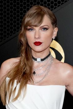 taylor swift in white dress with red lips and black choker on her neck, posing for the camera