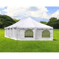 a large white tent sitting on top of a lush green field