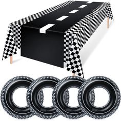 the table cloth is black and white checkered with four circles around it, along with three pairs of rubber tires