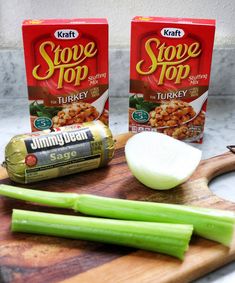 two boxes of soup sitting on top of a cutting board next to celery