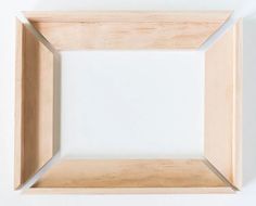 an empty wooden frame on a white wall