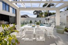 an outdoor dining area with white chairs and tables