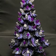 a purple glass christmas tree sitting on top of a table