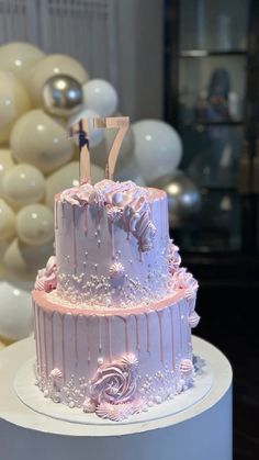 a white cake with pink icing and decorations