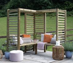 a wooden bench sitting on top of a wooden deck next to a lush green field