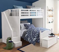 a white bunk bed sitting next to a blue wall in a child's room