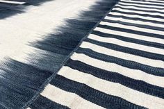 a black and white striped rug on the ground