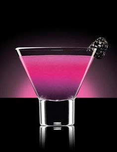 a purple and black drink in a glass with a cherry on the rim, against a dark background