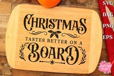 a cutting board with the words christmas tastes better on a board next to an orange