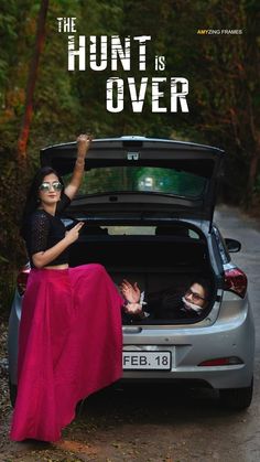 a woman sitting in the trunk of a car with her hand up to someone's head