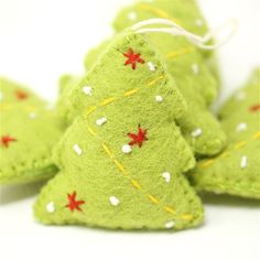 green felt christmas trees with red and white stars on them, sitting next to each other