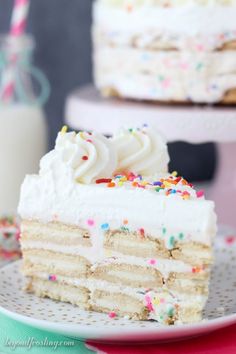 a slice of cake with white frosting and sprinkles on a plate