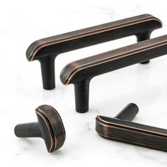 three black wooden handles on a white marble surface