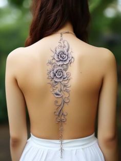 the back of a woman's neck is adorned with flowers and vines, while she wears a white dress