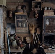 an old wooden room with brooms and other items