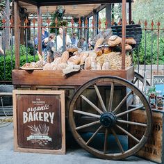 an old fashioned bakery cart with bread and pastries on display in front of it