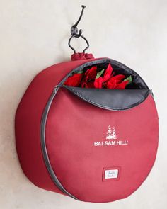 a red bag with flowers in it hanging on the wall