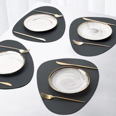 four place settings on a table with silverware