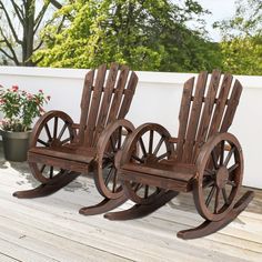 two wooden rocking chairs sitting on top of a wooden deck next to potted plants