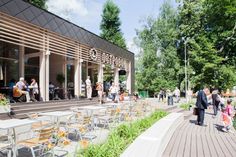 an artist's rendering of people walking in front of a restaurant with tables and chairs