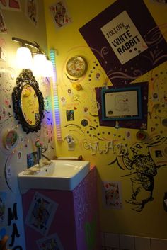 the bathroom is decorated in bright colors and has pictures on the wall above the sink