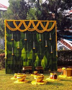 an outdoor stage set up in the grass with decorations on it and hanging from strings