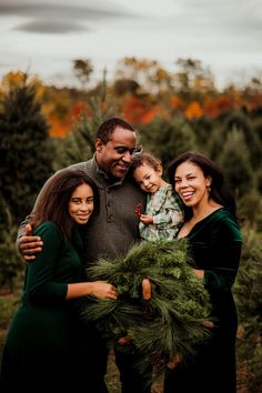 a family posing for a photo with christmas wreaths