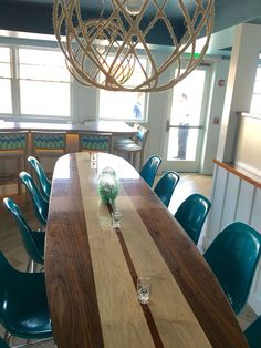 a wooden table with blue chairs and a chandelier